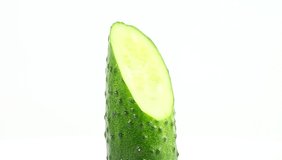 Green cucumber cut diagonally vertically rotate, spinning slowly in a circle, close up.