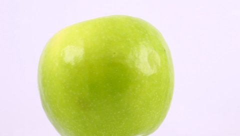 Apple green a whole one rotate, side view, spinning slowly in a circle, close up.