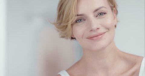 Close up portrait of beautiful woman smiling in luxury home enjoying relaxed lifestyle in front of soft out of focus background slow motion 6K RED EPIC DRAGON