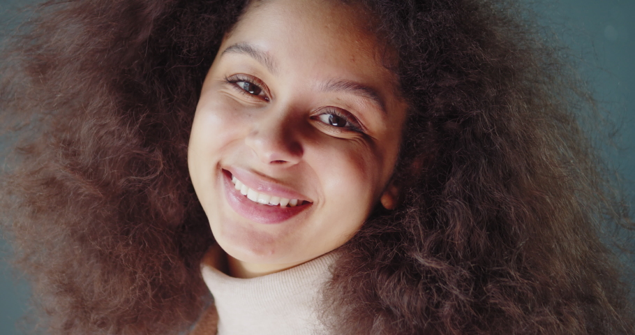 Portrait of beautiful cheerful latin american woman with afro hairstyle looking at camera, happy smiling black girl at home | Shutterstock HD Video #1051829569