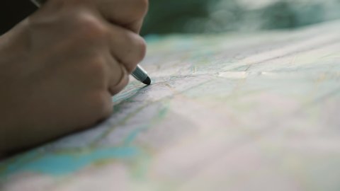 girl draws with felt-tip pen a line on a road map
