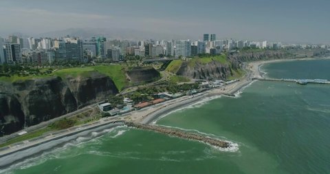 Aerial view with drone of the Miraflores boardwalk, the green coast and the Pacific ocean in Lima, Peru. 4K Video