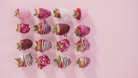 Time lapse. Flat lay. Step by step. Variety of chocolate dipped strawberries in white cupcake liners on a pink background.