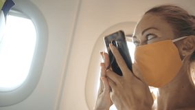 Woman travel tourist caucasian at plane aircraft with wearing protective medical mask. Girl talking about coronovirus on phone smartphone mobile. Virus epidemic sars-cov-2 covid-19 2019-ncov. - Powered by Shutterstock - Get 15% off with code: PIKWIZARD15