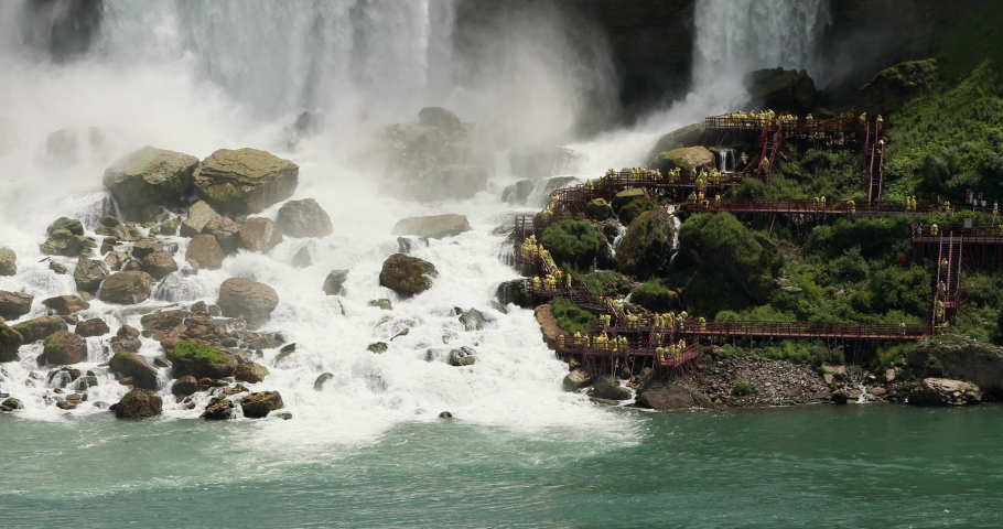 Niagara Falls tourist hike to bottom of falls turbulent river water mist. International border USA New York and Canadian province Ontario. honeymoon vacation destination.