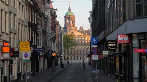 AMSTERDAM – MAY 03, 2020: Empty Dam Street and Dam Square on the morning of May 3, 2020 in Amsterdam during a partial lockdown due to COVID-19 (Coronavirus). View from Dam Street on Royal Palace.