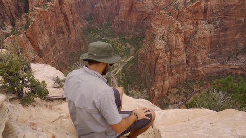 A young man at the top of the Angels Landing Trail trek in Zion National Park, Utah. United States