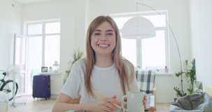Smiling young woman blogger vlogger influencer working at home. Girl speaking looking at camera talking making videochat or conference call, Female record blog vlog, 4k webcam view slow motion
