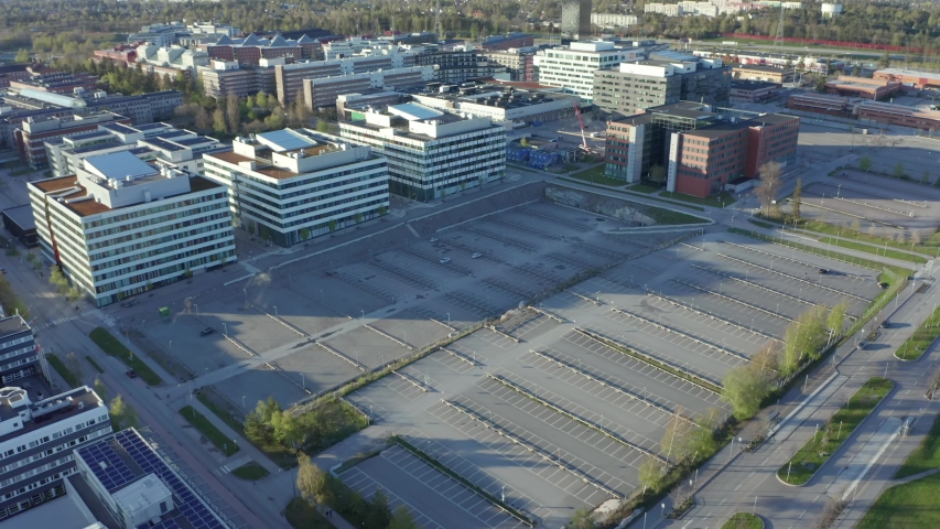 Drone shot of empty parking lot in front of shut down closed office buildings due to Corona virus pandemic. Aerial shot of free stalls with white painted lines car parking space. home office effect Royalty-Free Stock Footage #1051893550