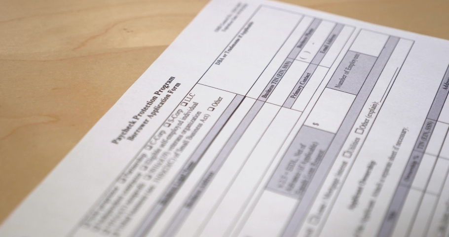 A closeup view of a business owner filling out the Paycheck Protection Program form. The PPP was a necessity for business owners during the 2020 COVID-19 pandemic to aid employee retention.	 Royalty-Free Stock Footage #1051894846