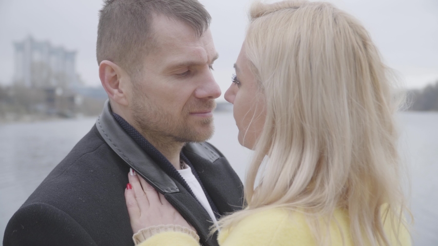 Close-up of loving couple dancing and rubbing noses. Caucasian man and woman looking at each other with love. Married couple dating on riverbank. Eternal love, unity, bonding, romance.