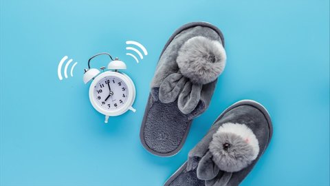 Stop motion animation with an alarm clock, slippers and a glass of water. The concept of good morning and morning ritual.