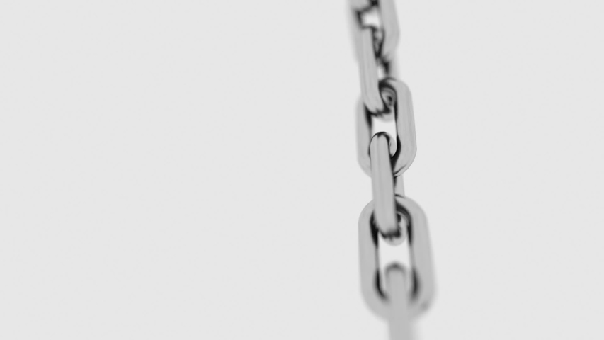 The metal chain coils quickly in front of the camera, showing off large links. Depth of field. Seamless loop.