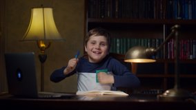 Autistic school boy making homework at home and gesticulating with hands very emotionally. Exited kid with autism jumping on chair.  - Powered by Shutterstock - Get 15% off with code: PIKWIZARD15