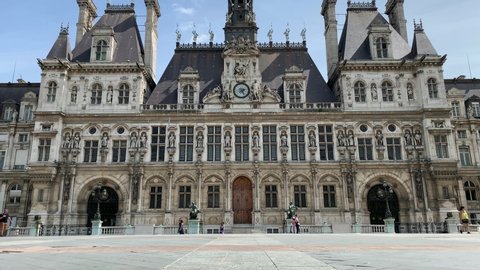 Time lapse footage of people walking in front of famous city government building called "Hotel De Ville" in Paris. It is a sunny summer day.
