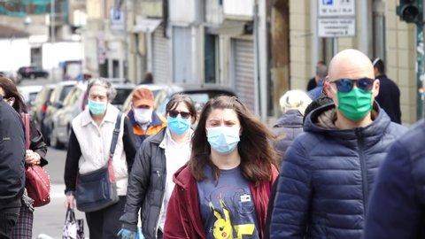 Coronavirus outbreak lifestyle: people walking down the street wearing coronavirus masks
Turin, Italy - April 2020
