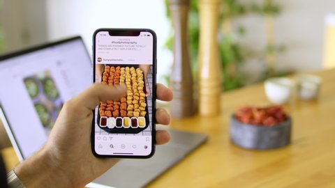 Melbourne , VIC / Australia - 01 23 2020: Man scrolls through food photography on Instagram using his phone