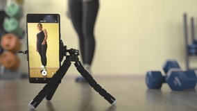Fitness training online. Woman conducts training on the Internet through a smartphone.