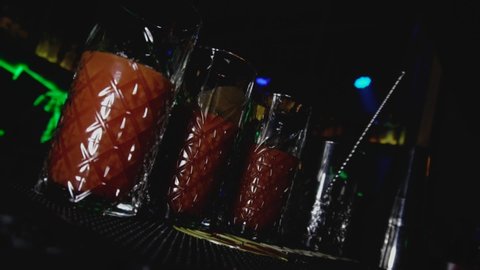 Highball glasses of alcoholic cocktail Bloody Mary are on the bar stool or tab in night club. Young lifestyle and relaxing in holidays concept. Dutch angle shot