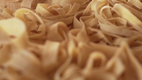 Macro close up tracking view of fresh home made tagliatelle pasta just rolled and cut with bokeh effect