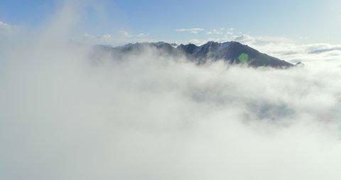 4k aerial view of drone flying above the sea of clouds in the mountain valley landscape in the morning sunrise