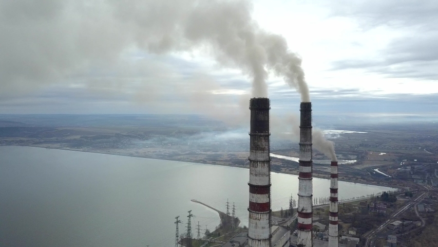 Aerial view of high chimney pipes with grey smoke from coal power plant. Production of electricity with fossil fuel. | Shutterstock HD Video #1051954558