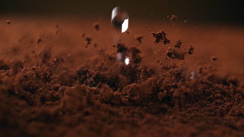 Slow Motion Macro Shot of Brewing Ground Coffee with Boiling Water Drops