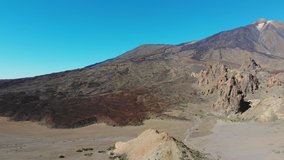 Aerial view footage of volcano Teide, Tenerife, Canary islands, Spain. Beautiful panorama with volcanic landscape, the peak of Teide, colorful rocks and solidified lava flows. 4K cinematic drone video