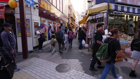 TOKYO - APRIL 04, 2018: Busy alleys intersection at Ameya Yokocho shopping area, first person view, walk forward. Popular market district near Ueno station, lively at day time, many people around