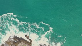 Sea waves crashing on the rocks. Morning in the Pacific. Video made from a drone.
