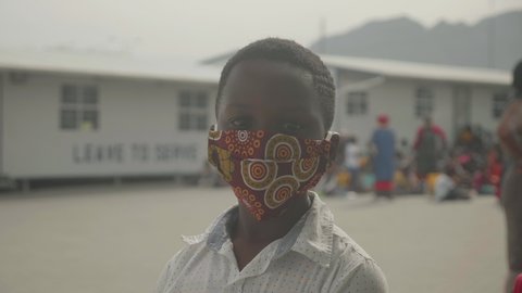 Young black African girl in township wearing a mask during South Africa's lockdown.