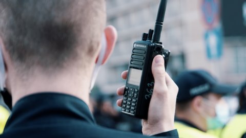 Warsaw, Poland, 05.07.2020 - Protest of the Entrepreneurs, Officer using walkie talkie or police radio during the demonstrations. Slow motion