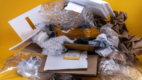 Pile of plastic bags and boxes accumulating - stop motion animation on yellow backdrop 4k