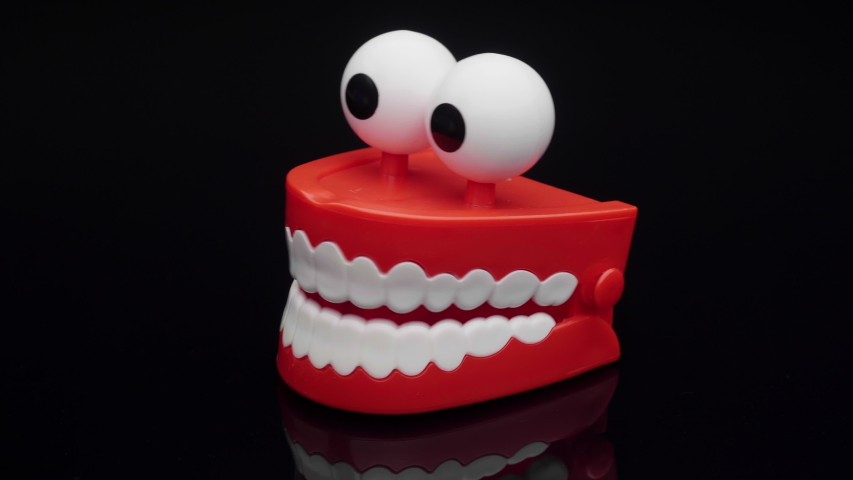 Toy teeth. Moving funny tooth model toy. Сhattering teeth toy moving on white background. | Shutterstock HD Video #1051999306