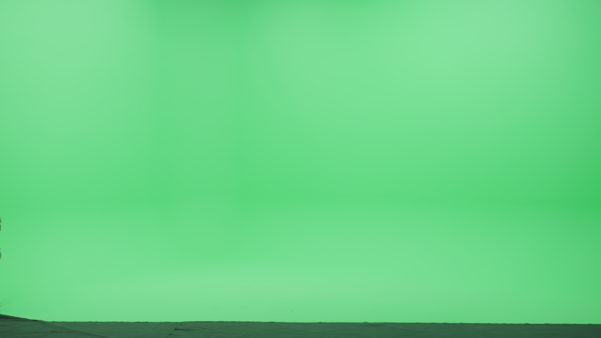 Green Screen Chroma Key Studio: Beautiful Blonde Woman Wearing Stylish Coat Walks Across Room Right to Left. Side View Camera Shot Royalty-Free Stock Footage #1052003944