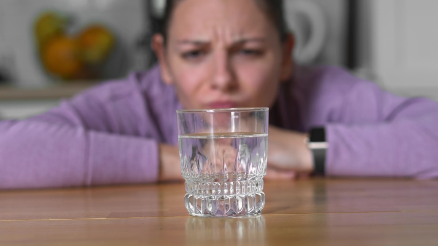 Young woman at home drinks water and wants to eat. Intermittent fasting concept. waiting for eating window Royalty-Free Stock Footage #1052005387