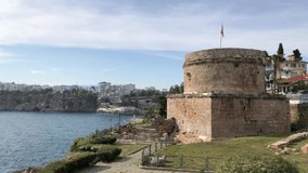 4k video of ancient Hidirlik Tower Castle in Kaleici, Antalya, Turkey. Landscape of Antalya old town and Mediterranean sea. 