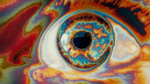 Hypnotic Eye Approaching Psychedelic Seamless Loop. Extreme close up of an wide opened eye in a psychedelic effect. Loop Ready
