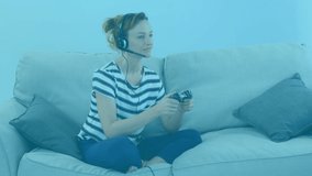 Animation of Caucasian woman wearing headset, playing video game with blue boxes floating. Social distancing with technology at home during quarantine lockdown concept digitally generated