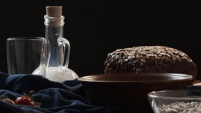 Drops of milk fall into a clay plate, dark background, slow-motion video, side view