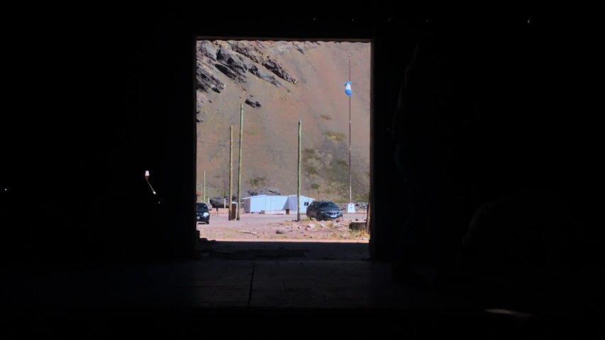Silhouette of a Woman playing with a Dog inside an Old Abandoned Train Wagon in Las Cuevas, Andes Mountains, Argentina. 4K Resolution.