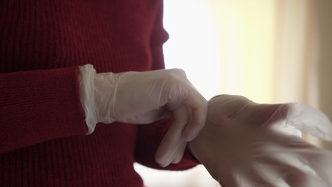Woman Wearing Latex Gloves on Hands to Prevent Transmission of Pathogens Protecting Himself from Coronavirus Outbreak Pandemic. Woman Puts on Protective Gloves Before Leaving House During Quarantine.