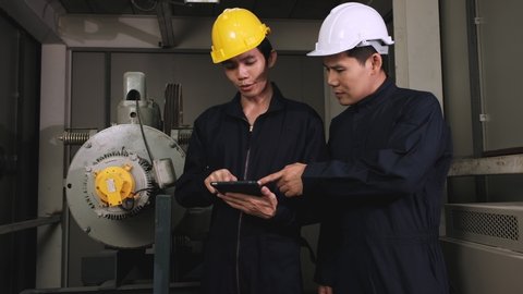 Two technician looking at tablet to analyzing problems of elevator control systems.