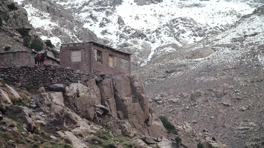 Small house while Toubkal trek with the Moroccan Atlas filled up of snow in the back.
High angle, slow motion, HD.