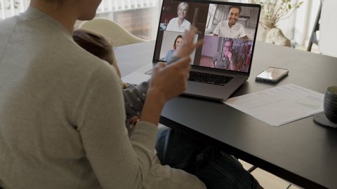 Woman and daughter at home having a video conference with her family and friends. Woman talking with her friends over internet.
