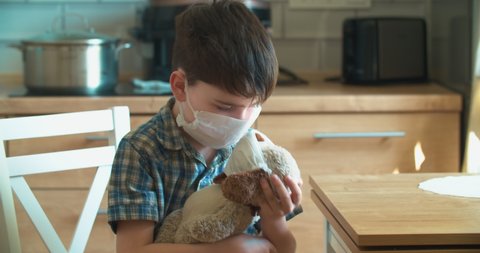 A child with a toy in a mask, a child measures the temperature. Cute video Coronavirus epidemic. Kovid 19. Pandemic.
