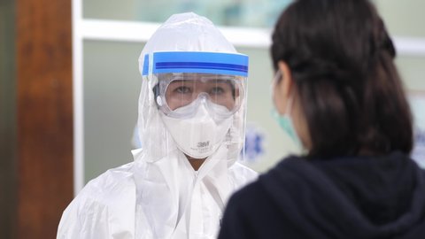 Cheerful female doctor in PPE suit personal protective equipment  and showing thumbs up gesture,corona virus covid19 concept.