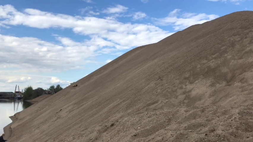 A girl climbs a sand mound. She overcomes difficulties