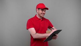 Delivery Man Writing in Clipboard and Gives Parcel to Client. Delivery Boy Home Delivery. Carton Box. Man with Clipboard in Hands