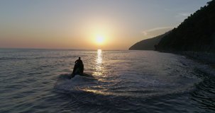 AERIAL TOP: water scooter is sailing on the sea at sunset. sport riding a personal watercraft. stunt riding on jet ski. riding a new model of water bike on the sea. Sports and floating video footage